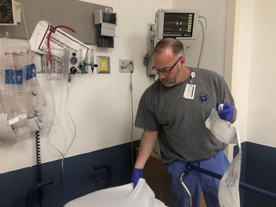 Emergency department nurse Cary Hamilton changes the sheets on an emergency room bed in preparation for a new patient at Saint Francis Hospital-Bartlett on Feb. 14, 2023.