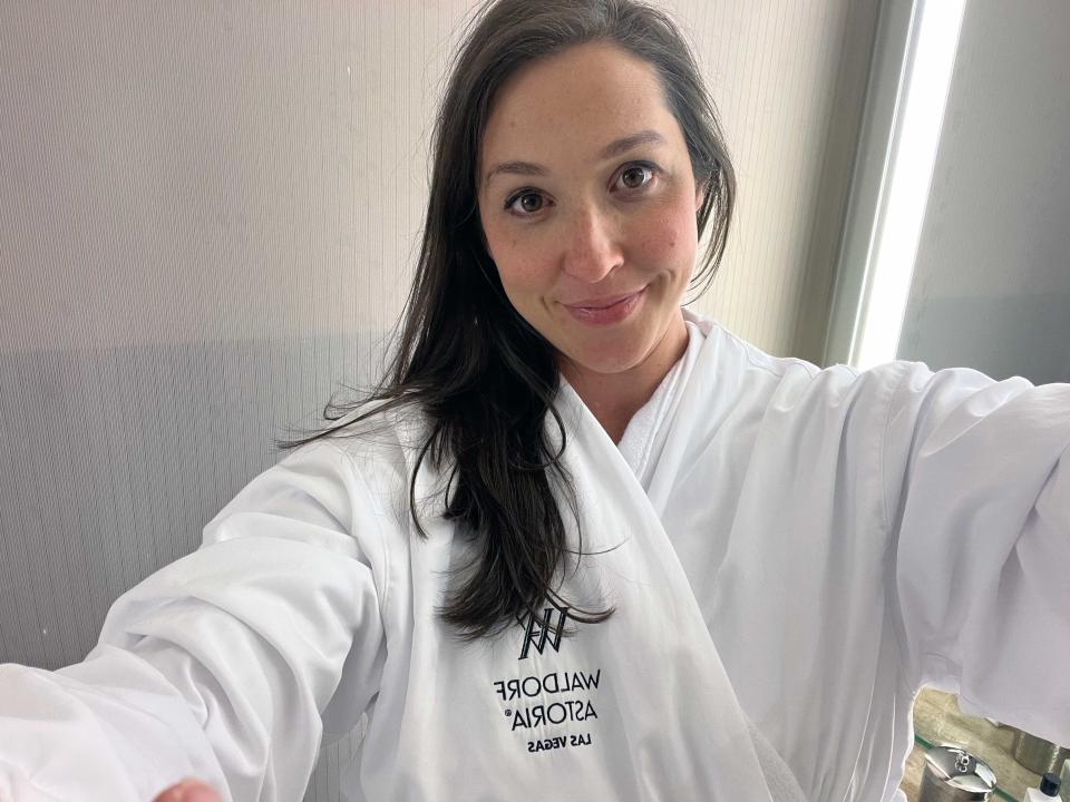 A woman taking a selfie wearing a hotel robe.