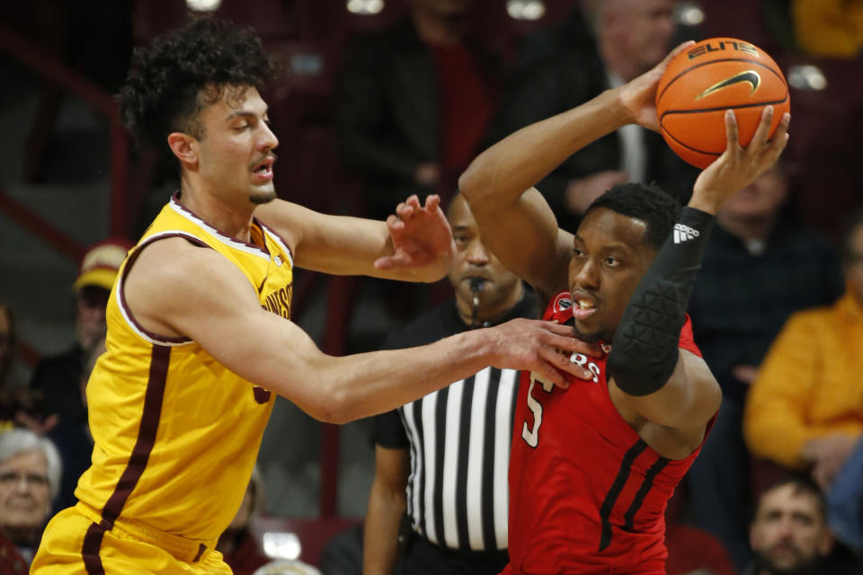 Rutgers forward Aundre Hyatt (5) looks to pass the ball as Minnesota forward Dawson Garcia defends during the first half of an NCAA college basketball game Thursday, March 2, 2023, in Minneapolis. (AP Photo/Bruce Kluckhohn)