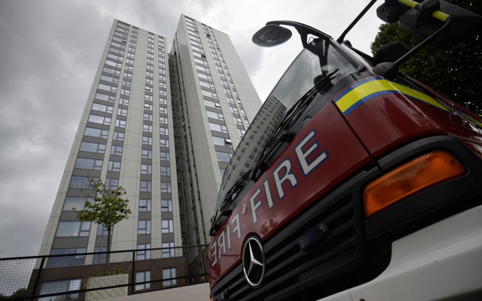 A fire engine is parked outside the Burnham Tower residential block, as residents were evacuated as a precautionary measure following concerns over the type of cladding used on the outside of the buildings in north London - Credit: Reuters