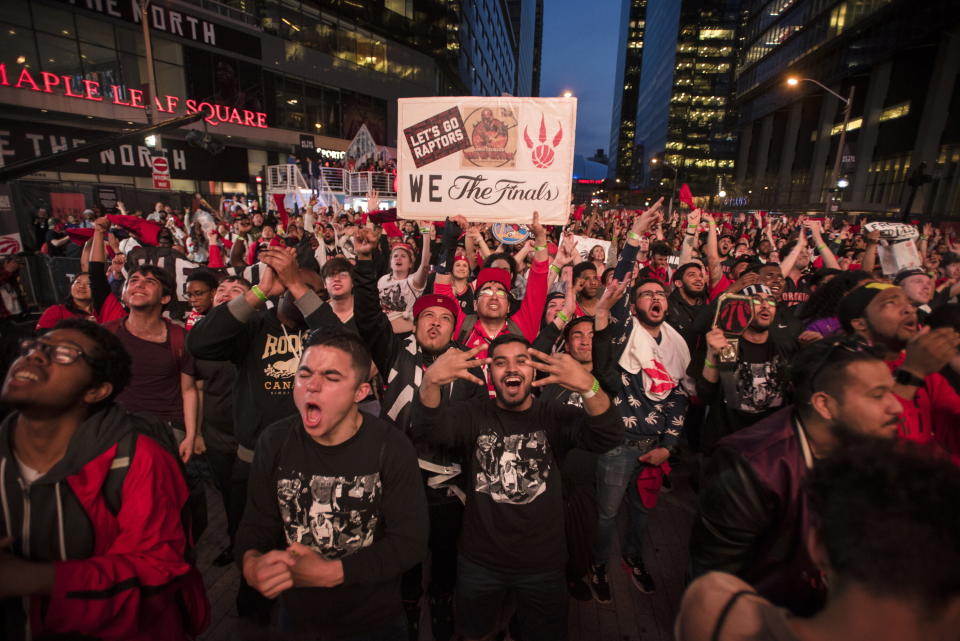 Toronto Raptors fans react in "Jurassic Park" outside Scotiabank Arena after the Raptors made their first basket in Game 1 against the Golden State Warriors in basketball's NBA Finals in Toronto on Thursday, May 30, 2019. (Tijana Martin/The Canadian Press via AP)