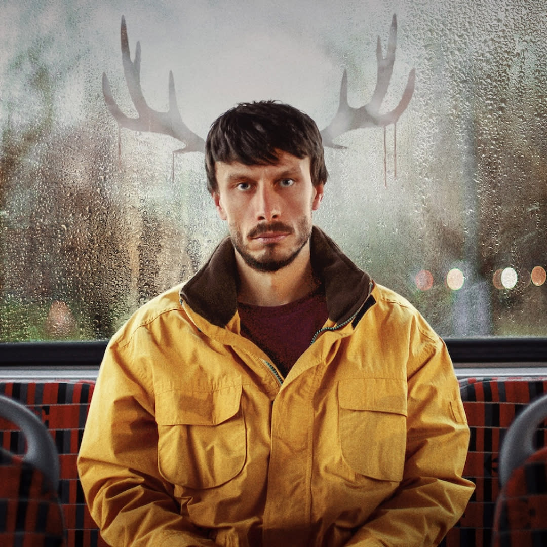  Richard Gadd as Donny Dunn, sitting at the back of the bus with reindeer antlers reflected in the window, in a promo image from the show 'baby reindeer'. 