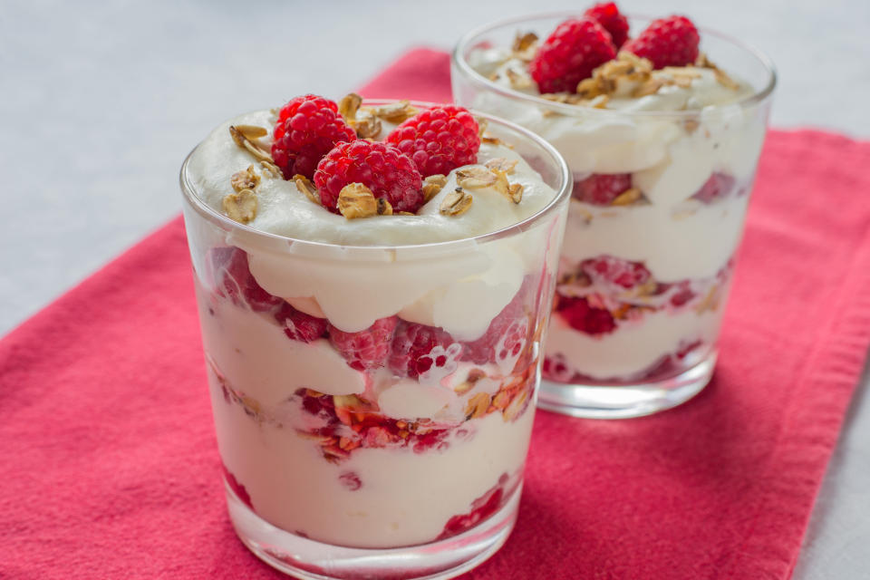 Cranachan - Traditional Scottish dessert with raspberry, whipped cream, roasted oatmeal and whisky on a table.