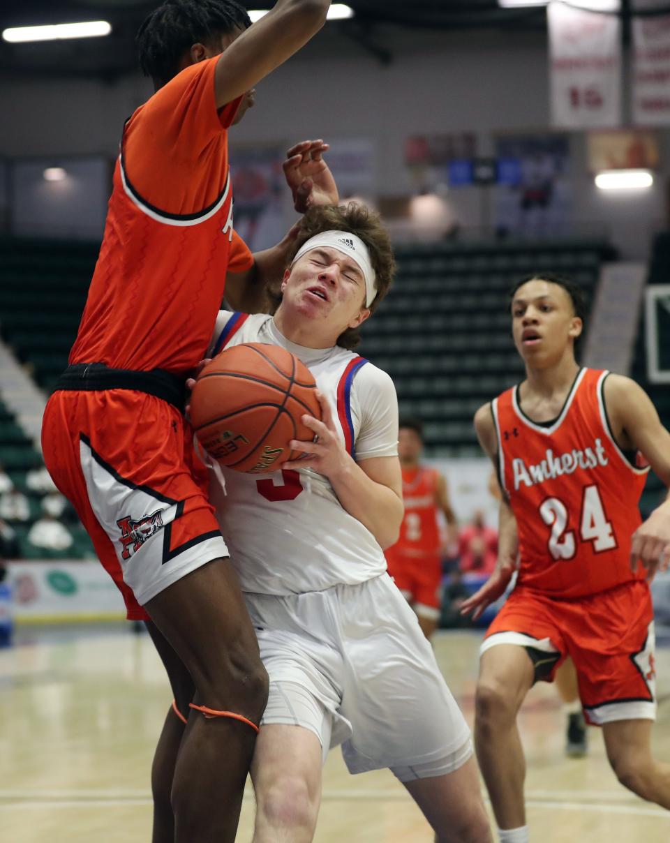 New Hartford's Andrew Durr (3) runs into Amherst's Gary Johnson (5) as he drives to the basket during the NYSPHSAA  Class A semifinal game at Cool Insuring Arena in Glens Falls, New York March 19, 2022. 