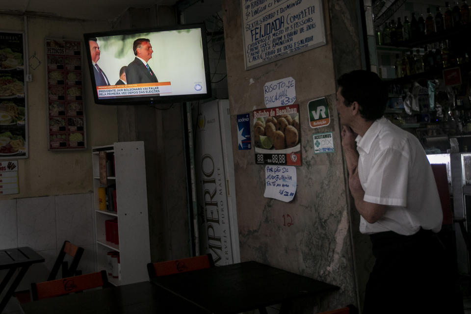 A waiter watches Brazilian President Jair Bolsonaro on TV during his first public comments since he lost the presidential runoff to former president Luiz Inacio Lula da silva, in Rio de Janeiro, Brazil, Tuesday, Nov. 1, 2022. (AP Photo/Bruna Prado)