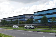 Vehicles pass the S11@Punggol foreign worker's dormitory compound, Friday, April 17, 2020 in Singapore. The city state is the latest Southeast Asian nation to surpass 5,000 COVID-19 cases, after more than 600 new cases were reported Friday. The health ministry said most of the new cases are foreign workers living in crowded dormitories. (AP Photo/YK Chan)