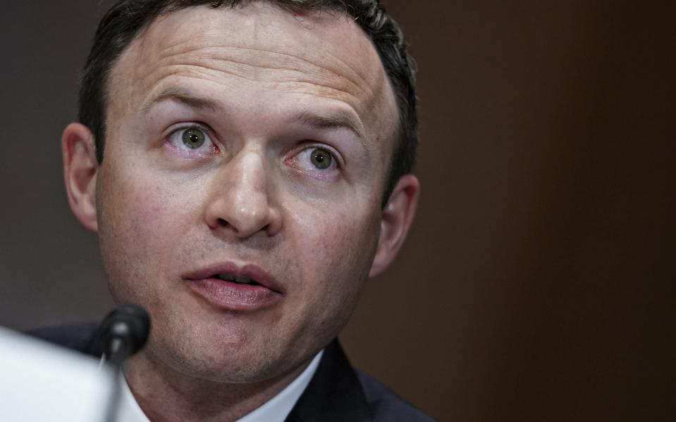 A close-up shot shows Jared Sine, a pale-skinned man in middle age with a head the shape of an upturned egg and wide, alert green eyes, speaking into a microphone while testifying in Washington, DC - Stafani Reynolds/Bloomberg