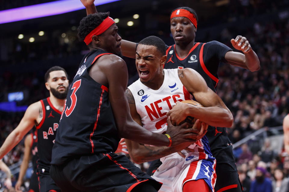 Brooklyn Nets centrer Nic Claxton, front right, tries to keep the ball away from Toronto Raptors forward Pascal Siakam (43) during the second half of an NBA basketball game in Toronto, Friday, Dec. 16, 2022. (Cole Burston/The Canadian Press via AP)