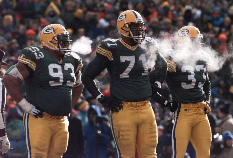 The breath of the Green Bay Packers' Gilbert Brown (93), Santana Dotson (71) and Doug Evans (33) is seen during the 1996 NFC Championship Game against the Carolina Panthers at Lambeau Field. The Packers won the game, 30-13, in one of the coldest games ever at Lambeau Field.