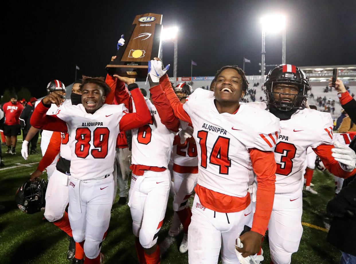 Aliquippa players carry the championship trophy after defeating Bishop McDevitt 34-27 in the PIAA Class 4A championship football game, Dec. 9, 2021, at HersheyPark Stadium in Hershey. 