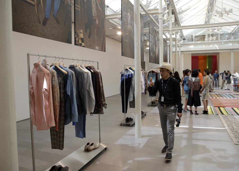 Attendees look at creations from the Missoni men's Spring-Summer 2020 collection, at a presentation during the fashion week, in Milan, Italy, Sunday, June 16, 2019. (AP Photo/Luca Bruno)