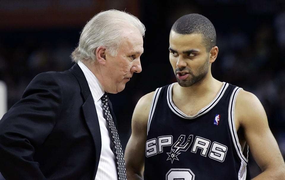 Główny trener San Antonio Spurs, Gregg Popovich (z lewej), słucha Tony'ego Parkera podczas drugiej połowy meczu NBA przeciwko Golden State Warriors, 2 lutego 2006 roku w Oakland w Kalifornii.  Spurs pokonali Warriors 89:86.  REUTERS/Kimberly White