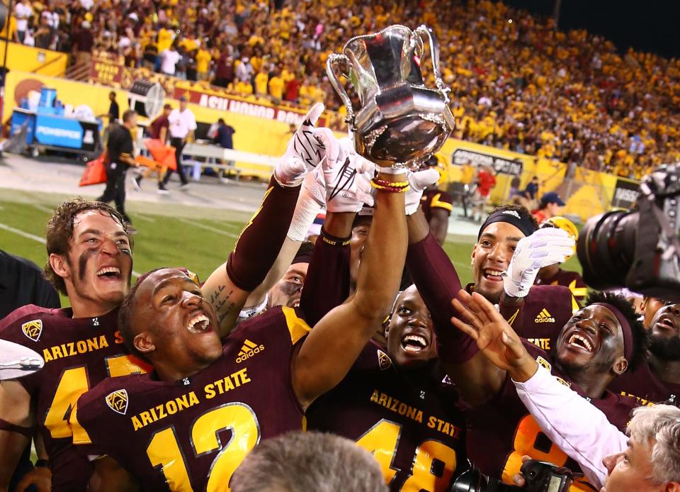 Territorial Cup: Arizona State Sun Devils players celebrate with the Territorial Cup trophy after defeating the Arizona Wildcats at Sun Devil Stadium.