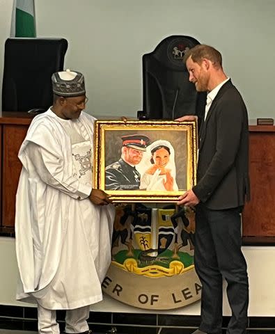 <p>Simon Perry</p> Prince Harry accepts a painting of him and Meghan Markle on their wedding day during visit to Kaduna, Nigeria, on May 10, 2024