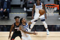 Minnesota Timberwolves guard D'Angelo Russell (0) goes up to shoot as Miami Heat forward Jimmy Butler (22) and guard Anthony Edwards (1) look on during the first half of an NBA basketball game, Friday, May 7, 2021, in Miami. (AP Photo/Wilfredo Lee)