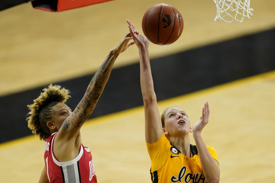 Iowa forward Logan Cook drives to the basket past Ohio State guard Rikki Harris, left, during the second half of an NCAA college basketball game, Wednesday, Jan. 13, 2021, in Iowa City, Iowa. Ohio State won 84-82 in overtime. (AP Photo/Charlie Neibergall)