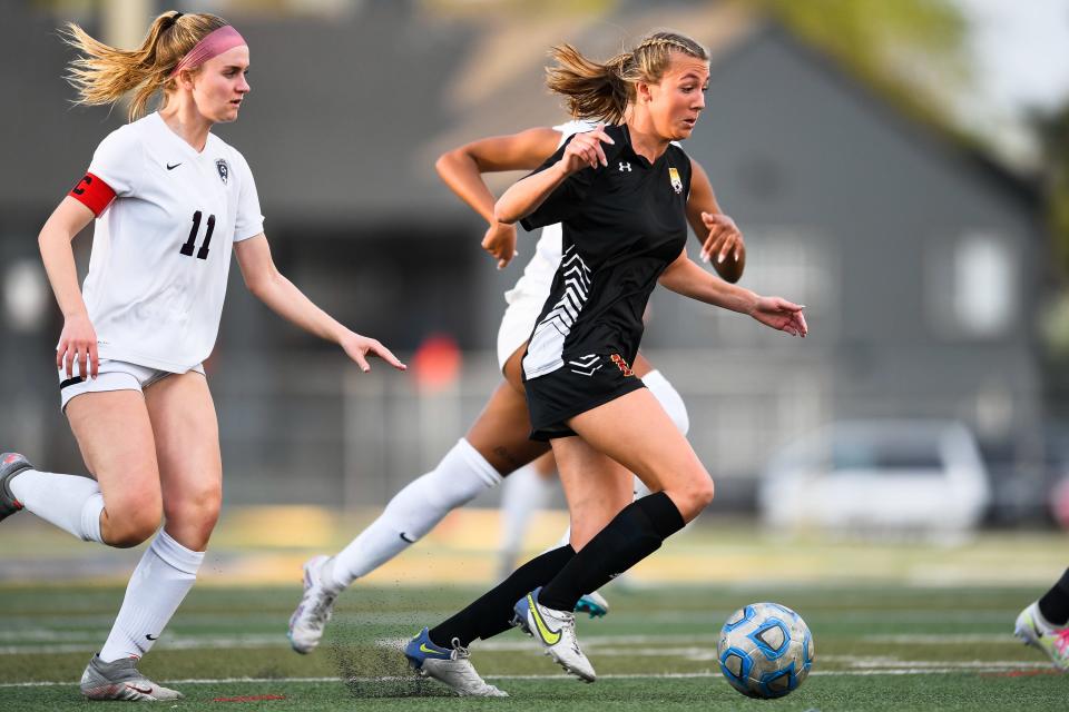 Rocky Mountain girls soccer player Jace Holley (13) weaves through defenders during a high school playoff game against Cherokee Trail on May 9, 2023, in Fort Collins, Colo. The Lobos won 2-1.