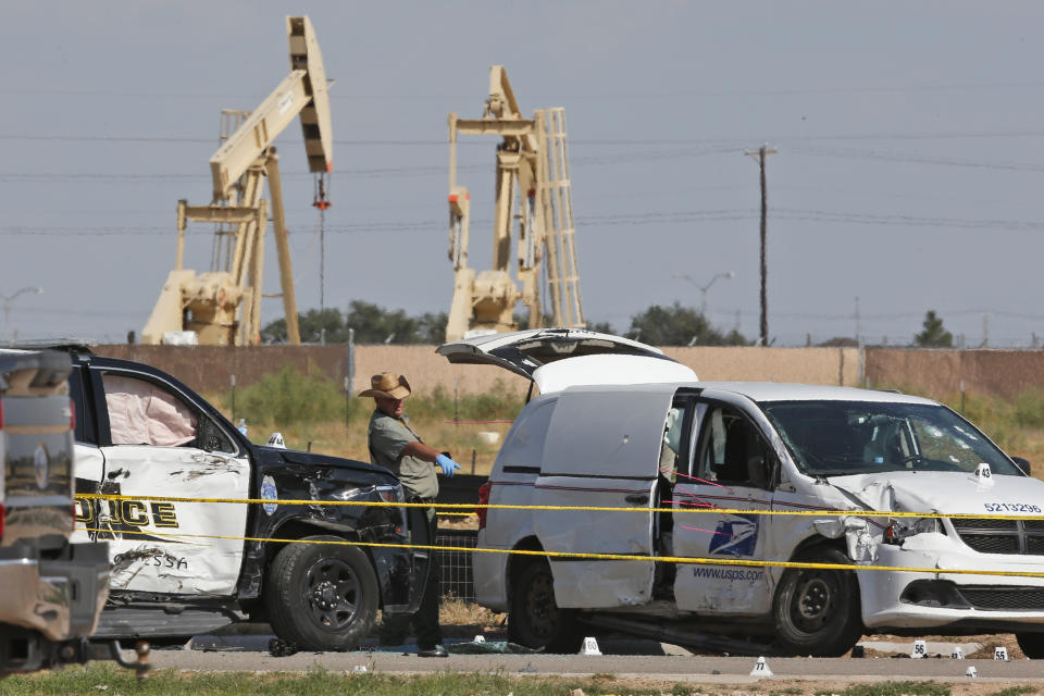FILE - In this Sunday, Sept. 1, 2019, file photo, law enforcement officials process the crime scene from Saturday's shooting which ended with the shooter, Seth Ator, being shot dead by police in a stolen mail van, right, in Odessa, Texas. The mass shooting in West Texas spread terror over more than 10 miles (16 kilometers) as Ator, fired from behind the wheel of a car. Ator zigzagged through Midland and Odessa, two closely intertwined cities now brought closer by tragedy. (AP Photo/Sue Ogrocki, File)