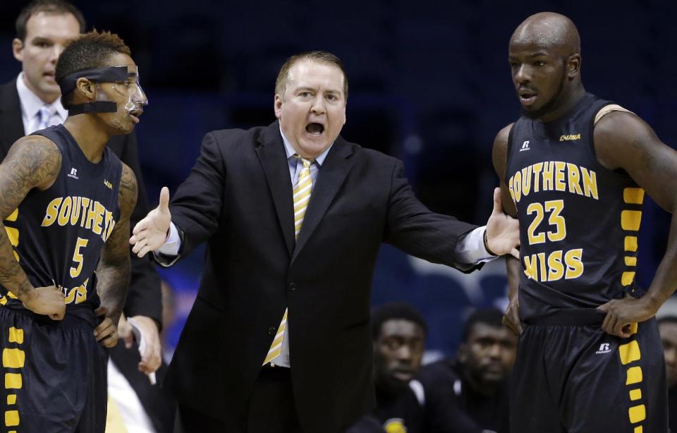 FILE - In this Nov. 13, 2013 file photo, Southern Mississippi head coach Donnie Tyndall, center, talks to guards Neil Watson, left, and Jerrold Brooks during the first half of an NCAA college basketball game against DePaul, in Rosemont, Ill. Tennessee is counting on Tyndall to make the same successful transition from the mid-major ranks as the Volunteers' last two men's basketball coaches. Tennessee announced Tuesday morning, April 22, 2014, that Tyndall would be introduced as its new coach at a 2 p.m. news conference. (AP Photo/Nam Y. Huh, File)