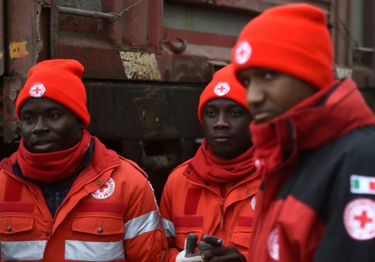 A group of migrants who volunteer with the Italian Red Cross stand at the Penna emergency operations center, 20 km from avalanche site that engulfed Hotel Rigopiano, in central Italy, on January 21, 2017