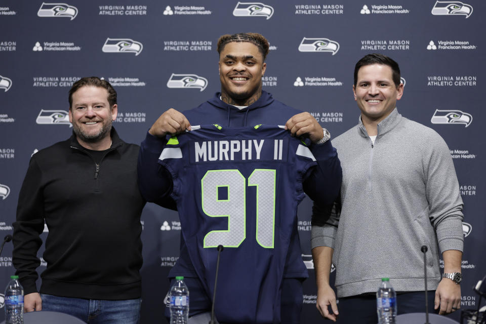 Seattle Seahawks 2024 first round draft pick, Byron Murphy II, is introduced by general manager John Schneider, left, and head coach Mike Macdonald, right, during a news conference at the NFL team's headquarters, Thursday, May 2, 2024, in Renton, Wash. (AP Photo/ John Froschauer)