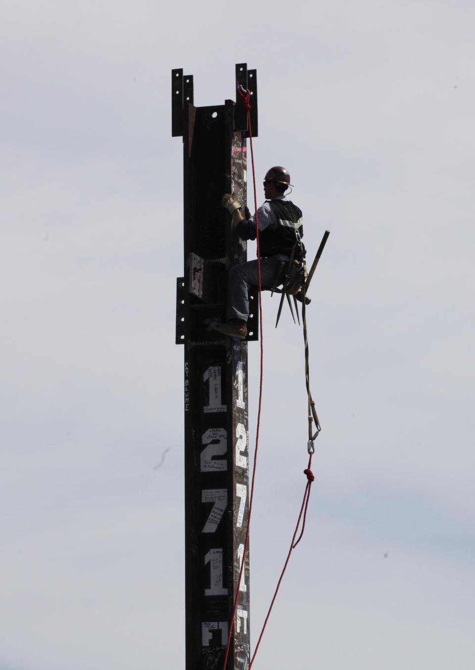 Ironworker Jim Brady climbs a column at the top of One World Trade Center to make it New York City's tallest skyscraper, Monday, April 30, 2012 in New York. One World Trade Center is being built to replace the twin towers destroyed in the Sept. 11 attacks. It reached just over 1,250 feet on Monday. That's just taller than the observation deck on the Empire State Building. (AP Photo/Pool, Mark Lennihan)