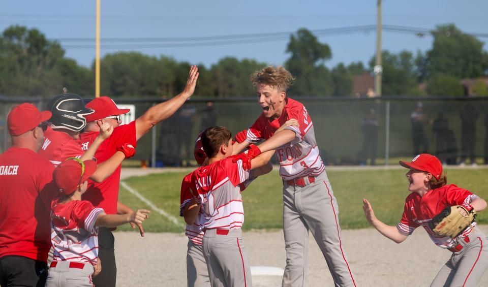 Pierce is mobbed by his Bedford Elite teammates after delivering a game-winning hit in a 7-6 victory over Ash Carleton Gold in the semifinals of the 63rd annual Monroe County Fair Baseball Tournament Wednesday.
