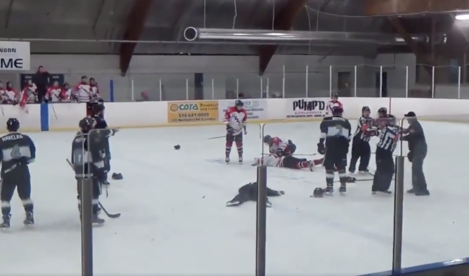 Carnage ensued after a linesman threw punches at a player and got hammered by a trainer. (Via HockeyFights.com)