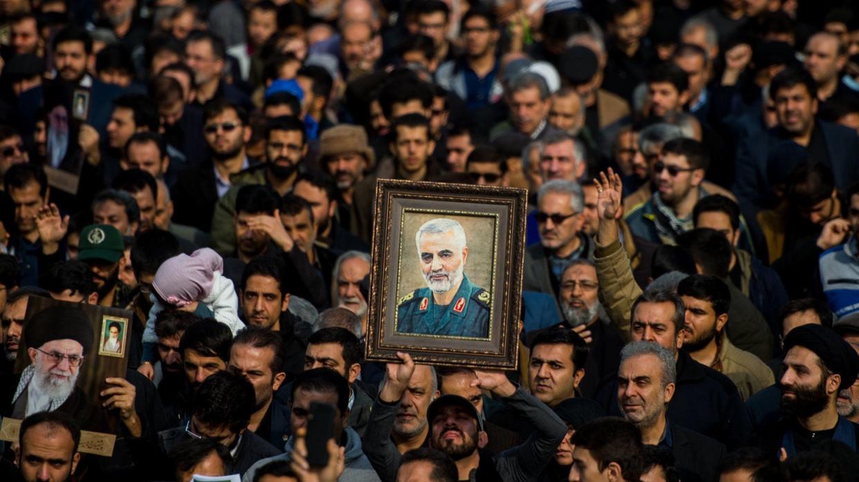 <p>Demonstrators hold up an image of Qassem Soleimani following his death</p> (Bloomberg via Getty)