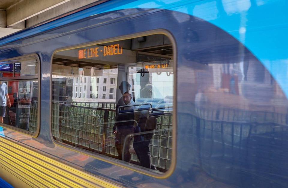 Usuarios que esperan para abordar la Orange Line en dirección a Dadeland se reflejan en la ventanilla del tren mientras un pasajero mira hacia el exterior, el miércoles 24 de julio de 2024, en el downtown de Miami, Florida. Usar el transporte público puede ser una opcíon que ahorre tiempo a algunos usuarios. Otros disfrutan de la posibilidad de realizar varias tareas a la vez o de relajarse durante el trayecto, ya que no tienen que concentrarse en la conducción.