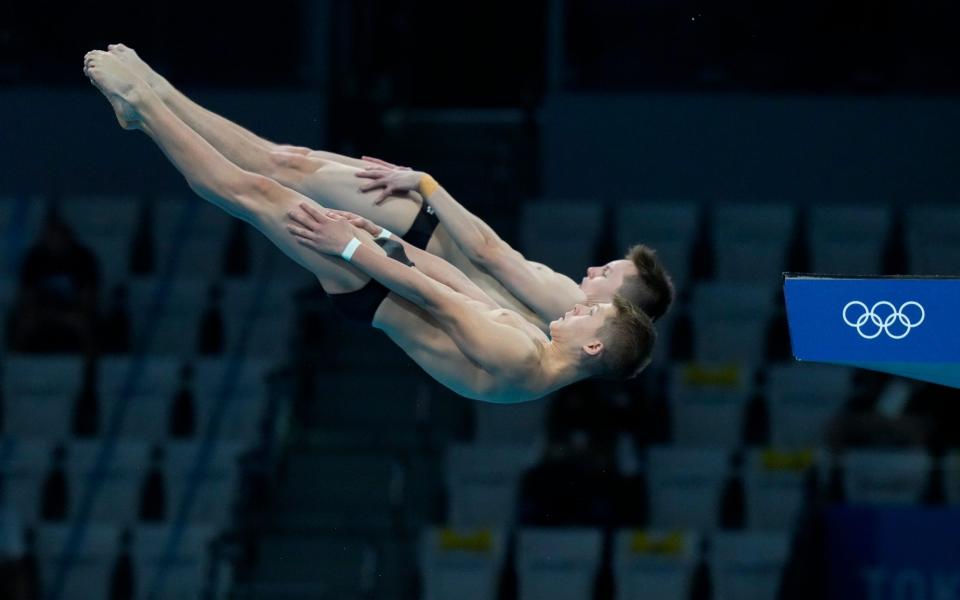 Oleh Serbin and Oleksii Sereda of Ukraine compete during the men's synchronized 10m platform diving final at the Tokyo Aquatics Centre at the 2020 Summer Olympics - AP Photo/Dmitri Lovetsky
