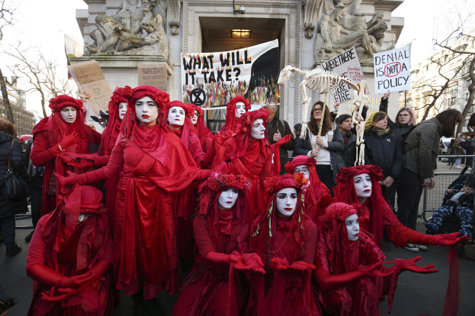 The Red Rebels join climate change protesters outside the Australian Embassy in London, where Extinction Rebellion are staging a protest against the Australian government's response to the wildfires in Australia, Friday Jan. 10, 2020. (Jonathan Brady/PA via AP)