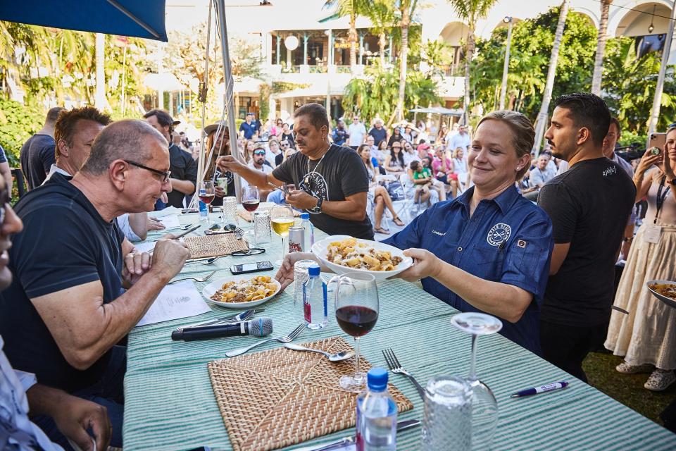 Chef Lindsay Autry presents Chef Jimmy Everett's winning pasta dish to a panel of celebrity judges Sunday during the Palm Beach Food and Wine Festival's "Grand Chef Throwdown" competition at The Square in West Palm Beach.