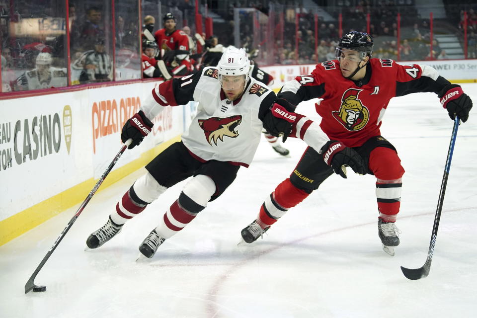 Arizona Coyotes left wing Taylor Hall (91) skates with the puck past Ottawa Senators center Jean-Gabriel Pageau (44) during first-period NHL hockey game action in Ottawa, Ontario, Thursday, Feb. 13, 2020. (Chris Wattie/The Canadian Press via AP)