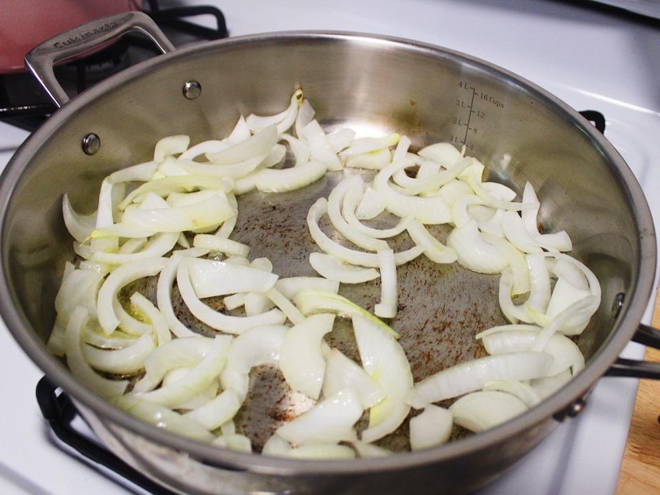 white onions sauteed in stainless steel pan