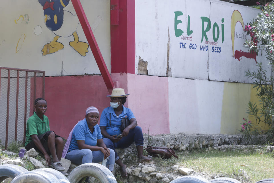 Staff sit in front of a school funded by El Roi Haiti in the Cite Soleil neighborhood of Port-au-Prince, Haiti, Monday, July 31, 2023. The non profit organization said in a statement that Alix Dorsainvil, a nurse who works for El Roi Haiti, and her daughter were kidnapped on July 27. (AP Photo/Odelyn Joseph)