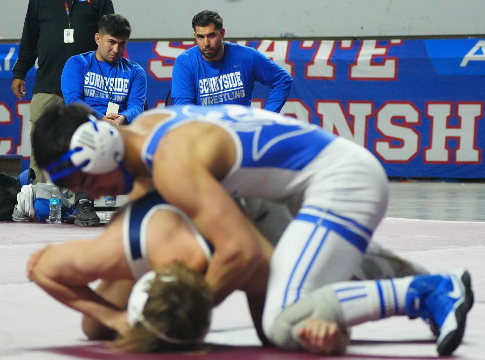 February 18, 2023; Phoenix, Ariz; USA; Sunnyside head coach Anthony Leon watches his Christian Rivera (R) wrestle Desert Vistas Damen Miller in the D1-144lbs State Championship match during the State High School Wrestling Championships at Veterans Memorial Coliseum. 