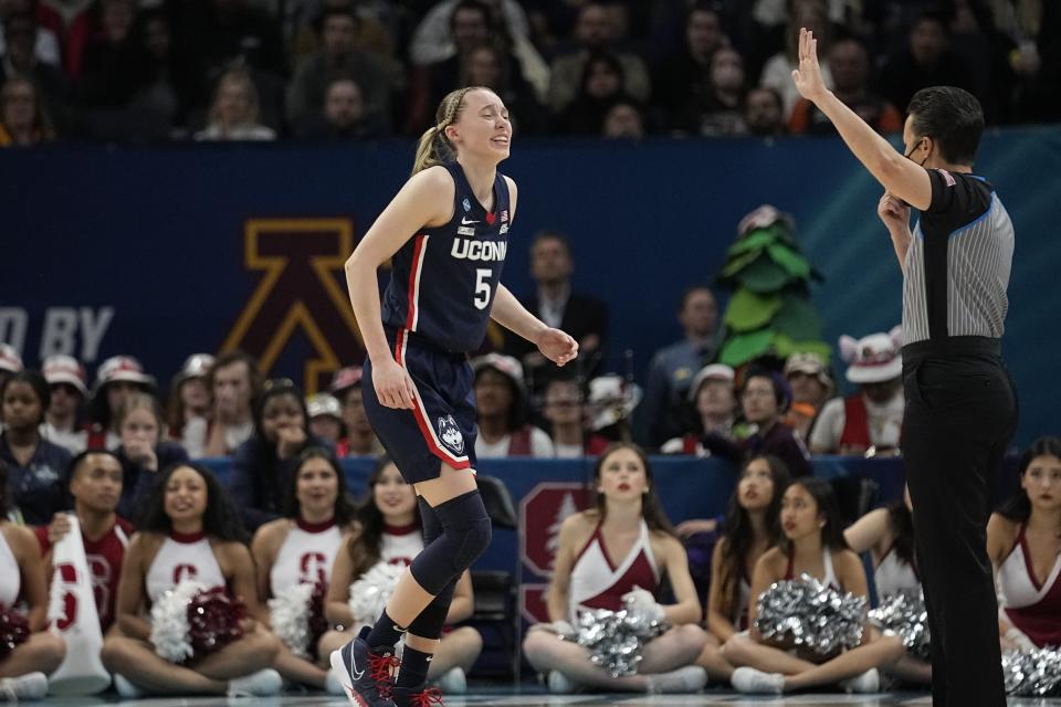 UConn's Paige Bueckers favors her leg as she walks off the court during the second half of a college basketball game in the semifinal round of the Women's Final Four NCAA tournament Friday, April 1, 2022, in Minneapolis. (AP Photo/Eric Gay)