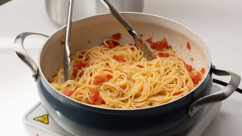 spaghetti and tomatoes in pan