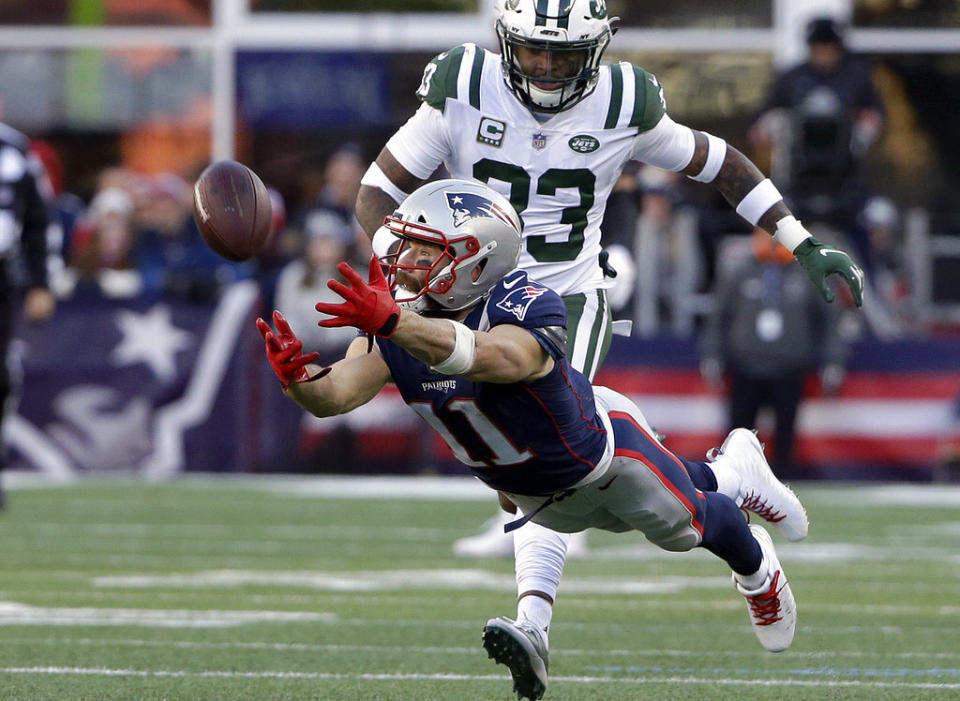 ADDS RETIREMENT ANNOUNCEMENT FILE — In this Sunday, Dec. 30, 2018 file photo New England Patriots wide receiver Julian Edelman (11) stretches but cannot catch a pass in front of New York Jets safety Jamal Adams, rear, during the second half of an NFL football game, in Foxborough, Mass. The Patriots terminated Edelman's contract with a failed physical designation Monday, April 12, 2021, according to the NFL's transaction wire. Citing a knee injury that cut his 2020 season short after just six games, Edelman announced Monday that he is retiring from the NFL after 11 seasons. (AP Photo/Steven Senne, File)