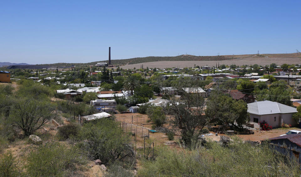 FILE - This June 15, 2015 file photo, shows the town of Superior, Ariz., with its once-bustling mining operations and derelict smelter tower in the background. The U.S. Forest Service released an environmental review Friday, Jan. 15, 2021, that paves the way for the creation of one of the largest copper mines in the United States, against the wishes of a group of Apaches who have been trying for years to stop the project. The mountainous land near Superior is known as Oak Flat or Chi'chil Bildagoteel. It's where Apaches have harvested medicinal plants, held coming-of-age ceremonies, and gathered acorns for generations. (AP Photo/Ross D. Franklin, File)