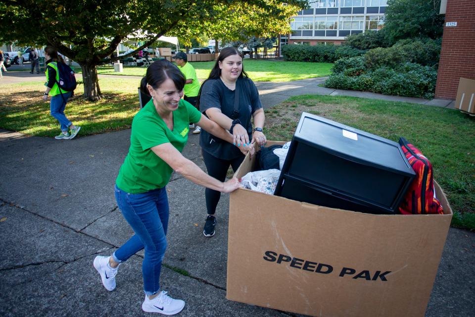 Ronda Marchica, left, and Maddi Coultrap move Coultrap’s belongings into her dorm during the University of Oregon’s move-in day Thursday.