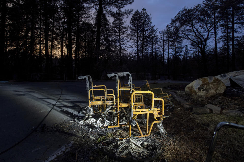 FILE - In this Dec. 4, 2018, file photo, scorched wheelchairs rest outside Cypress Meadows Post-Acute, a nursing home leveled by the Camp Fire in Paradise, Calif. A federal judge on Tuesday, May 7, 2019, ordered board members of Pacific Gas & Electric to tour the Northern California town of Paradise, which was leveled by a wildfire that may have been caused by the utility's equipment. The judge ordered the tour as part of the utility's punishment for violating its felony probation terms, reported the San Francisco Chronicle. (AP Photo/Noah Berger, File)