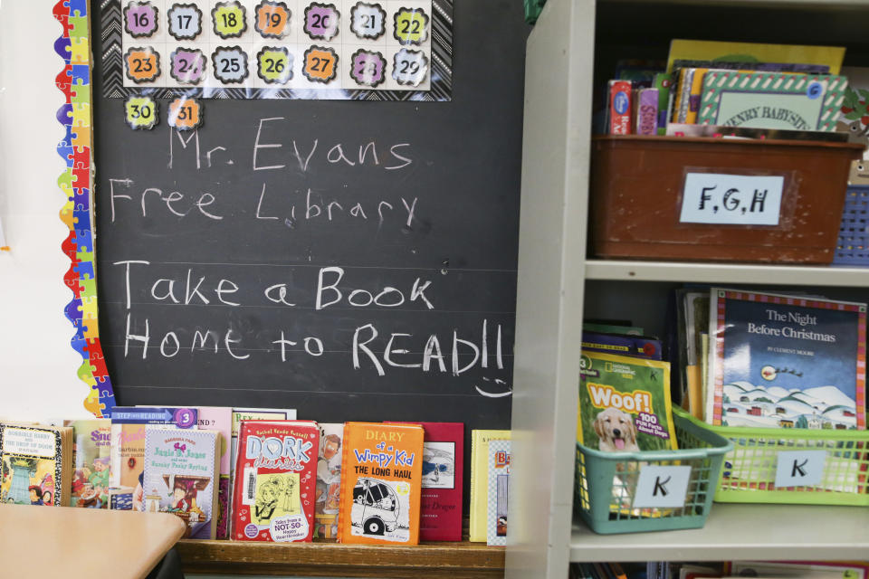 Books are displayed on a free library shelf inside the classroom of Richard Evans, a teacher at Hyde Park Elementary School, on Thursday, Oct. 20, 2022, in Niagara Falls, N.Y. Even after schools reopened full time for second grade, COVID-related obstacles remained: masking and distancing rules that prevented group work, quarantining that sent kids home for a week without warning, and young children by then unaccustomed to — and unhappy about — full weeks of school rules. (AP Photo/Joshua Bessex)