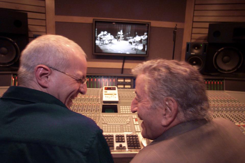 Dae Bennett and his father Tony Bennett, the famous singer, share a laugh at the sound board in his new recoding studio in Englewood, January 29, 2002. His studio is connected via fiber optics, to the John Harms Center, where the band Brock Mumford is playing, at top.