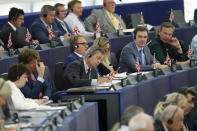 Brexit Party chairman Nigel Farage, center, writes some notes as Germany's Ursula von der Leyen delivers her speech at the European Parliament in Strasbourg, eastern France, Tuesday July 16, 2019. Ursula von der Leyen outlined her vision and plans as Commission President. The vote, held by secret paper ballot, will take place later today. (AP Photo/Jean-Francois Badias)