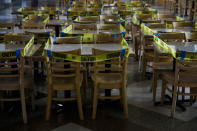 Caution tape is wrapped around dining tables and chairs at a food court to prevent indoor dining due to the coronavirus pandemic in the Koreatown section of Los Angels, Wednesday, July 8, 2020. (AP Photo/Jae C. Hong)