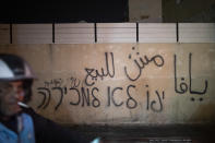 Graffiti on a wall in Arabic and Hebrew reads, "Jaffa is not for sale," in the predominantly Arab part of Jaffa, Tel Aviv, Israel, Saturday, April 24, 2021. Historic Jaffa's rapid gentrification in recent years is coming at the expense of its mostly Arab lower class. With housing prices out of reach, discontent over the city’s rapid transformation into a bastion for Israel’s ultra-wealthy is reaching a boiling point. (AP Photo/Ariel Schalit)