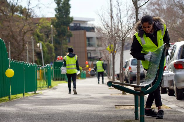 A sanitation worker cleans a bench outside the single remaining public housing tower under a lockdown in response to an outbreak of the coronavirus disease (COVID-19), in Melbourne, Australia July 10, 2020.  REUTERS/Sandra Sanders