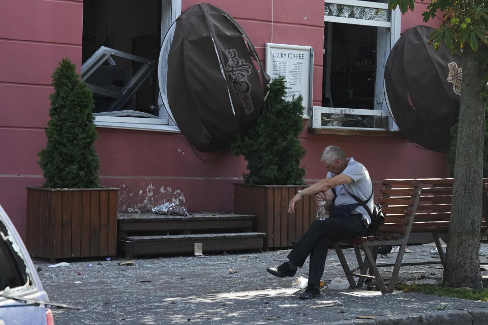 A man reacts next to a restaurant damaged by a Russian attack in Chernihiv, Ukraine, Saturday, Aug. 19, 2023. (AP Photo/Efrem Lukatsky)